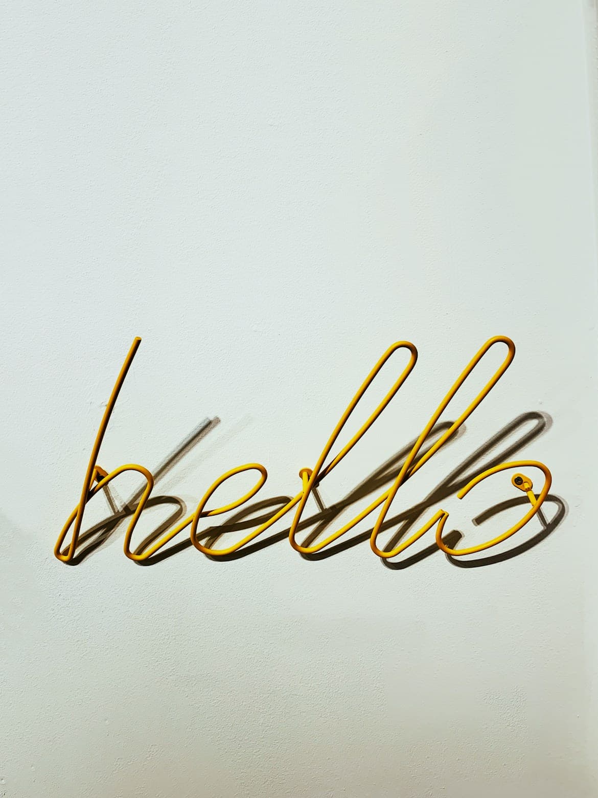 Neon wire sign reading hello on a wall